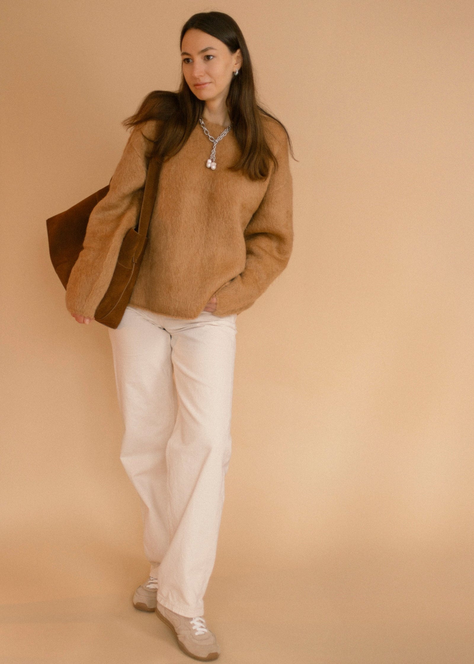 Full outfit shot featuring the Silver Rain necklace from Jewell Reef, paired with a caramel sweater, white jeans, and a suede bag.