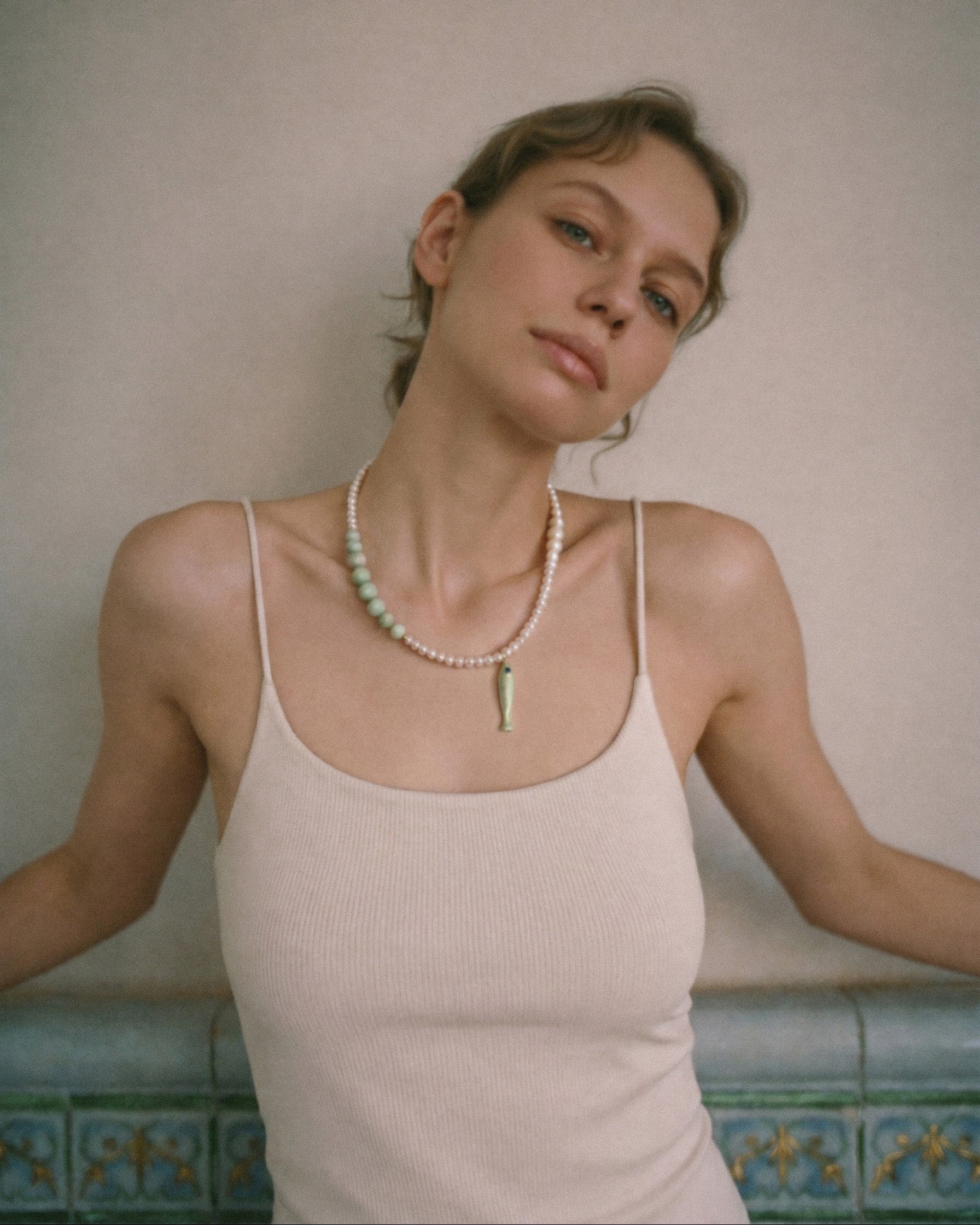 freshwater pearl and amazonite necklace with ceramic fish pendant worn in soft minimal editorial portrait