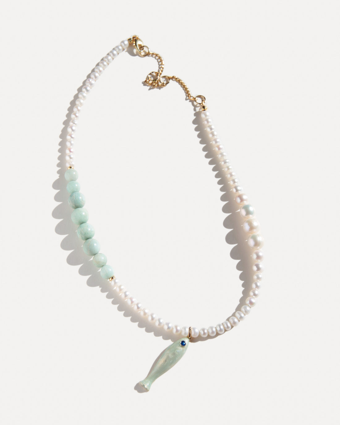 freshwater pearl necklace with pale amazonite beads, ceramic fish pendant and 18K gold-plated clasp on white background