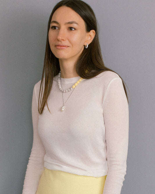 Minimalist Bare Pearl Necklace styled on model with simple white top. A timeless pearl pendant necklace in stainless steel, perfect for everyday wear.