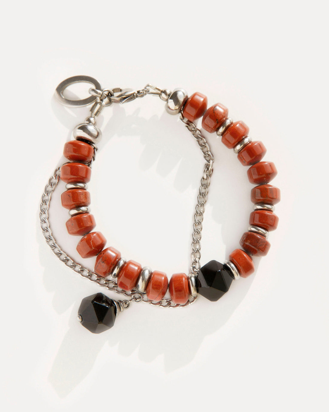 Red Outline Bracelet with terracotta jasper beads, faceted black agate, and stainless steel chain, blending bold geometry with urban-inspired elegance.