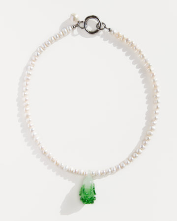 Freshwater pearl necklace with a green lampwork bok choy pendant and stainless steel clasp – minimal flat lay on white background.
