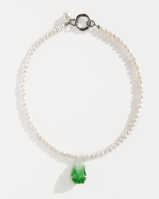 Freshwater pearl necklace with a green lampwork bok choy pendant and stainless steel clasp – minimal flat lay on white background.