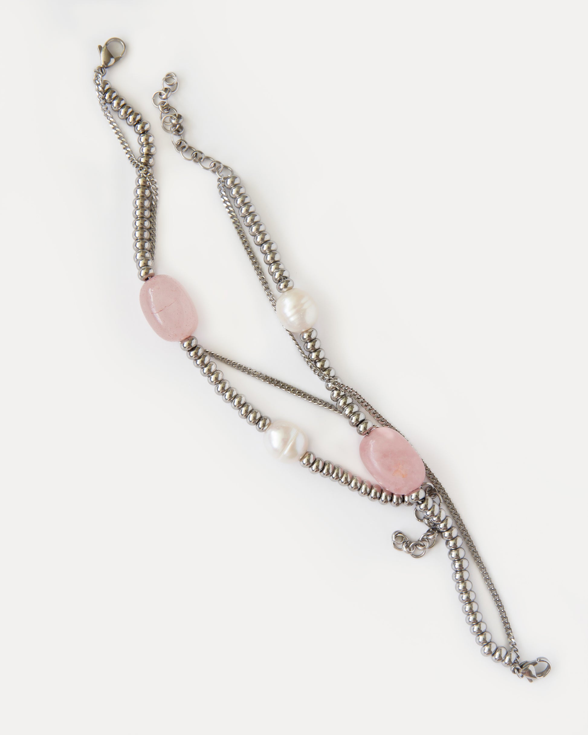 Candy Bracelet shown laid flat, highlighting its asymmetric composition with rose quartz, freshwater pearls, and polished stainless steel details.