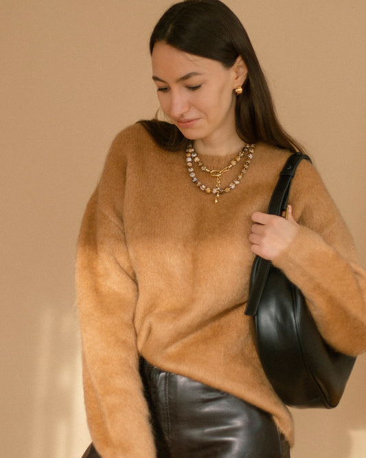 Model wearing Coffee Caramel Necklace layered with gold chains, styled with a caramel sweater and black leather skirt for a warm autumn look.