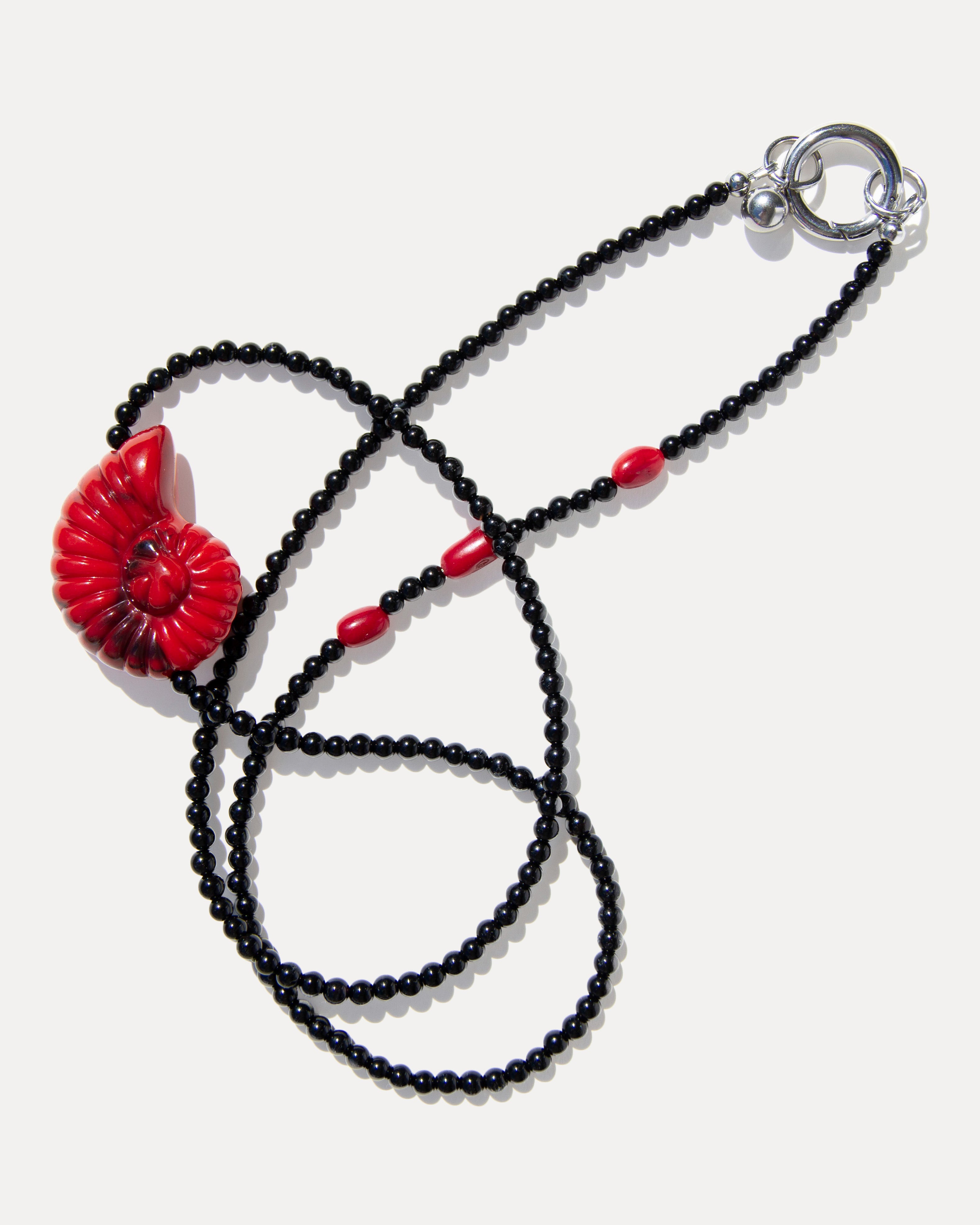 Red shell pendant necklace with glossy black agate beads, coral accents and a silver-tone clasp