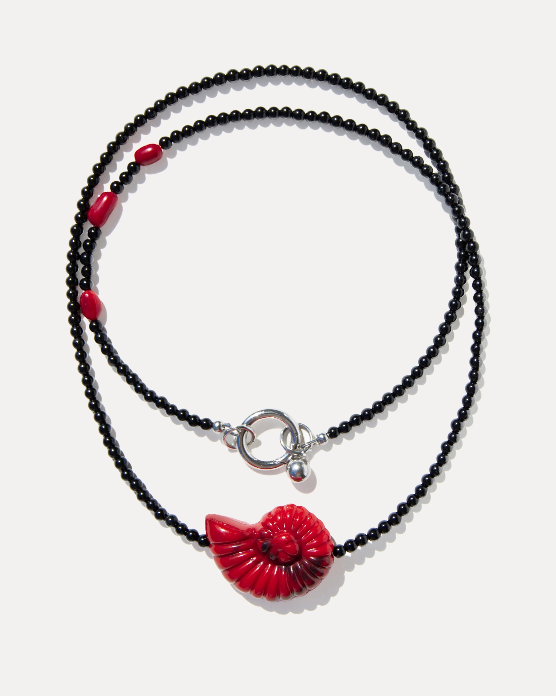 Layered black agate necklace with coral beads, a red shell pendant and silver-tone clasp