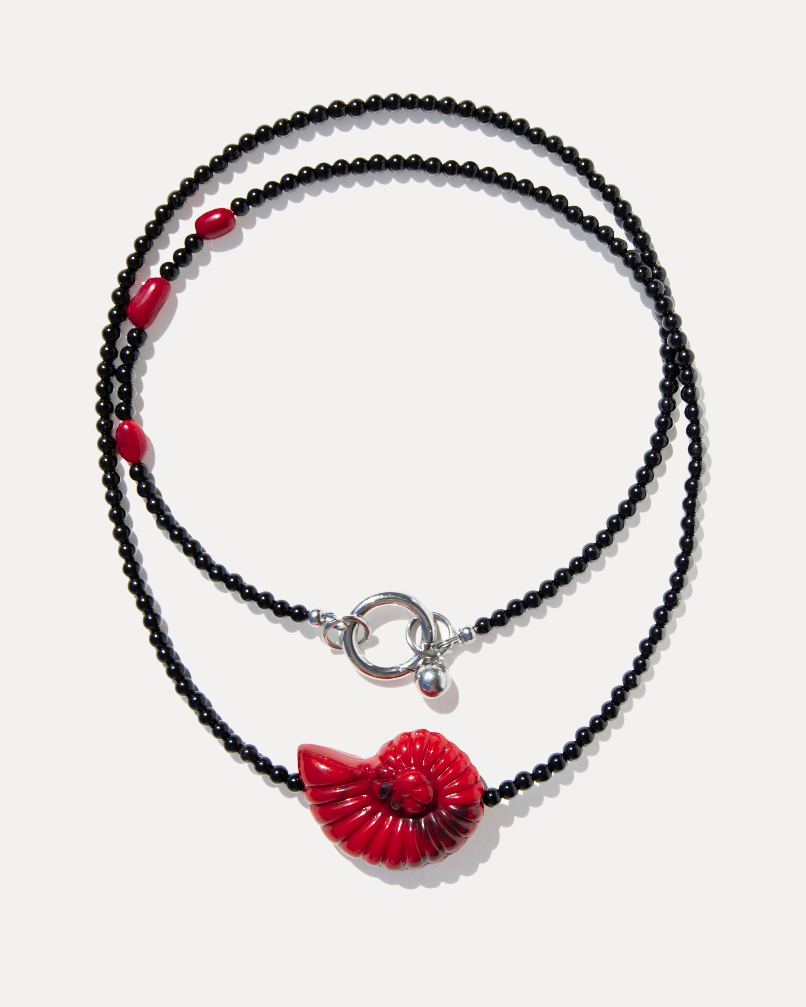 Layered black agate necklace with coral beads, a red shell pendant and silver-tone clasp