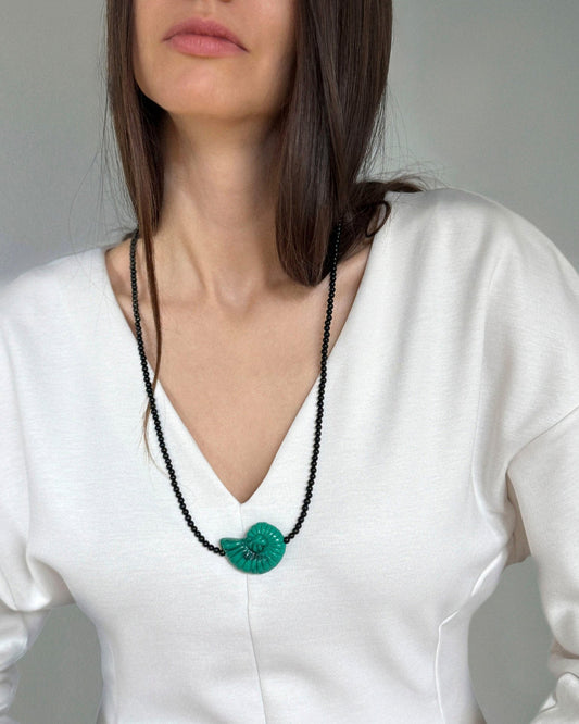 Emerald Shell Necklace styled on model, featuring glossy black agate beads, soothing amazonite accents, and a sculptural green shell pendant.