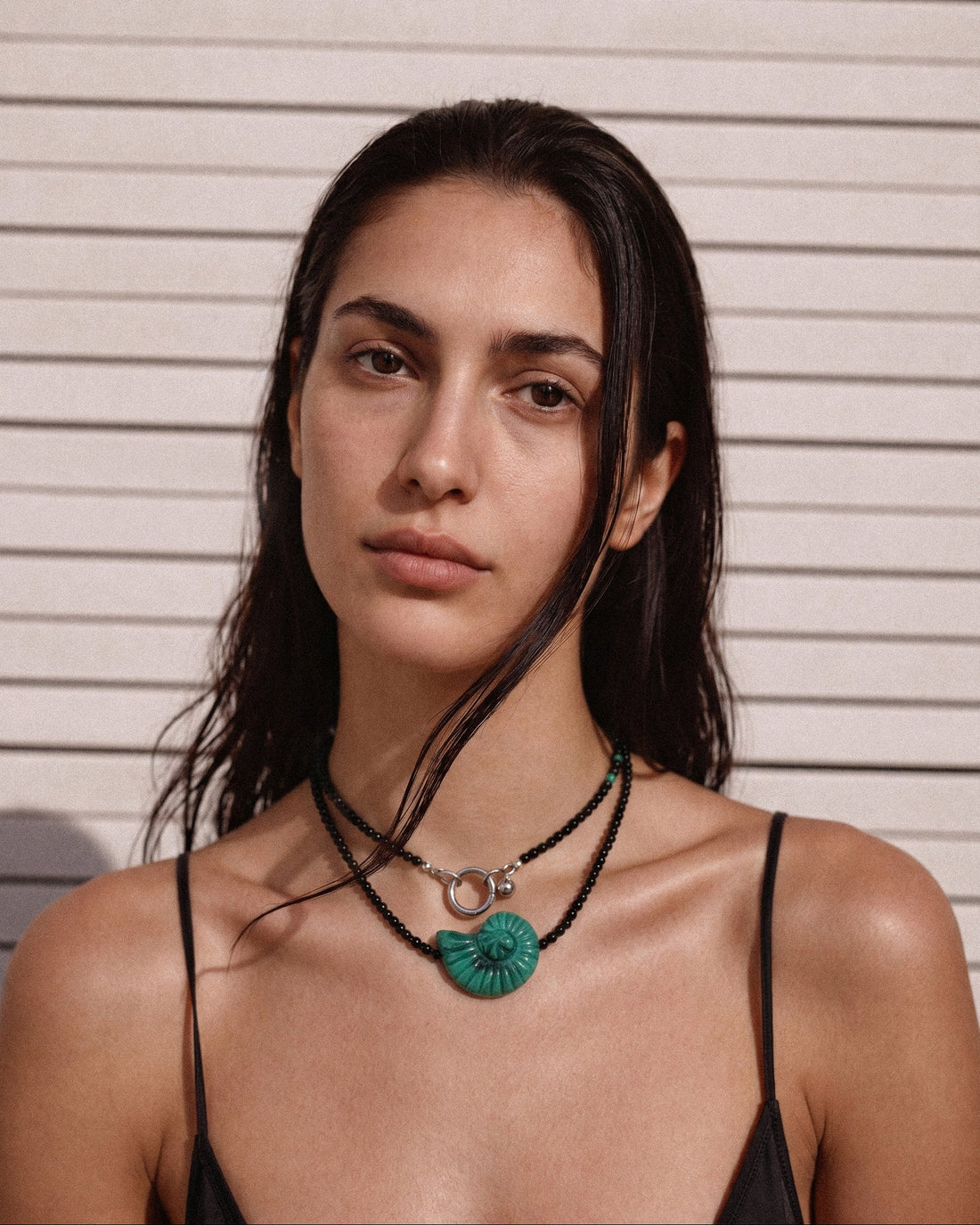 Emerald Shell Necklace with black agate beads, amazonite accents, and sculptural green shell pendant, handmade by Jewell Reef.