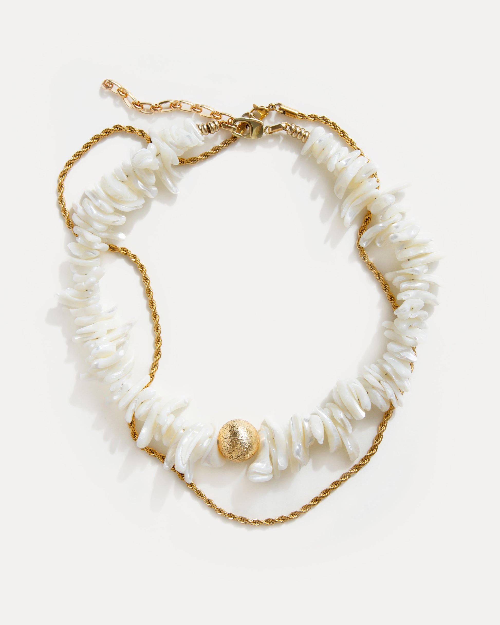 statement shell choker necklace with white shell beads and twisted 18K gold-plated chain arranged on white background