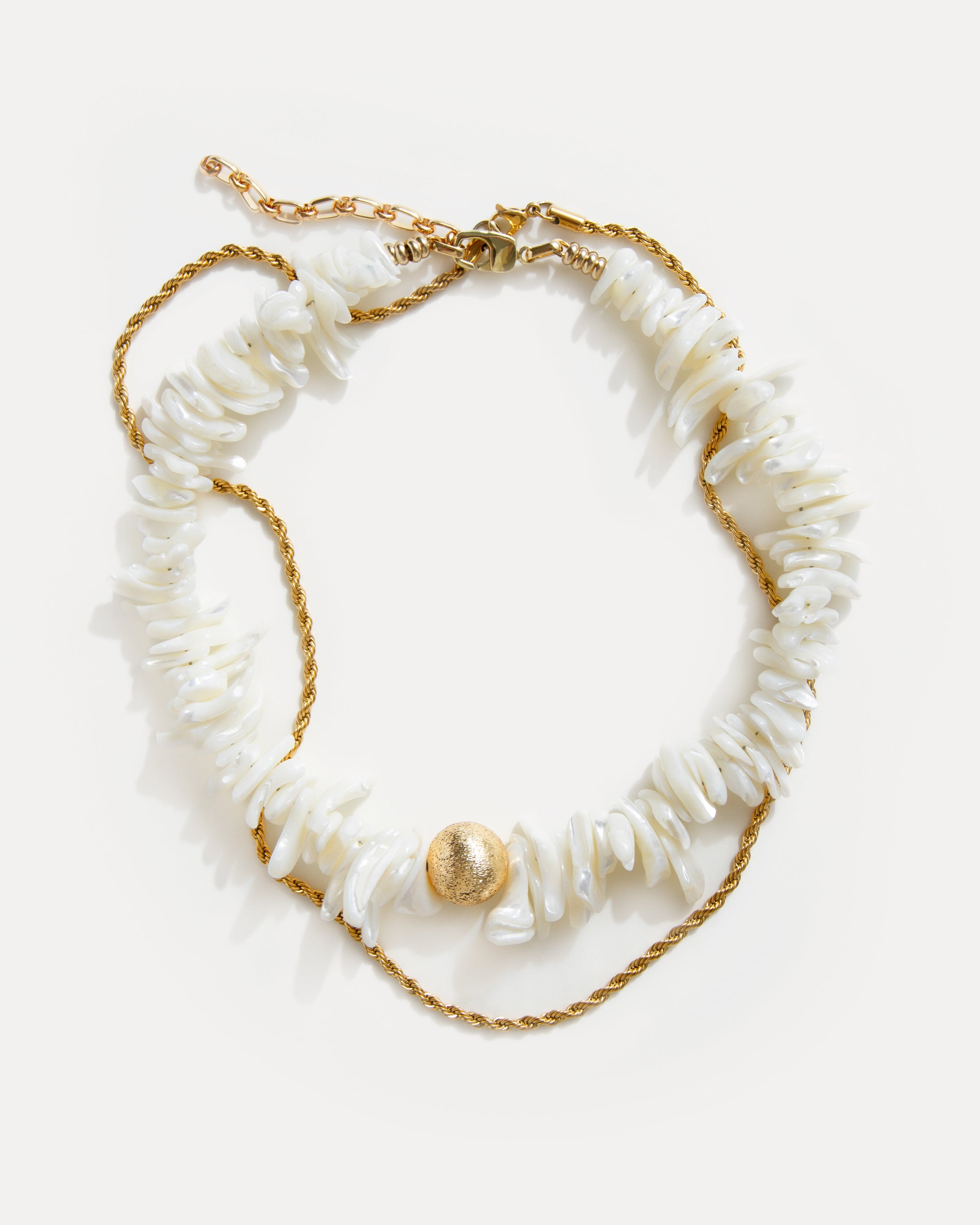 statement shell choker necklace with white shell beads and twisted 18K gold-plated chain arranged on white background