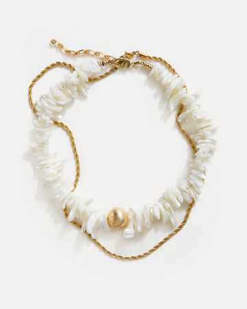 statement shell choker necklace with white shell beads and twisted 18K gold-plated chain arranged on white background
