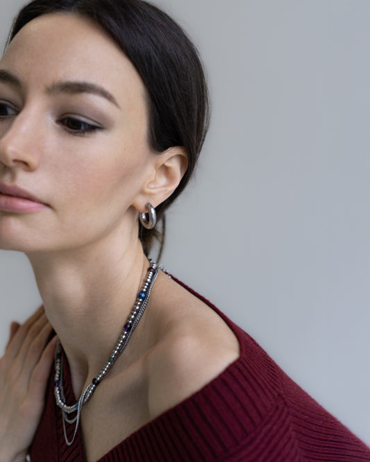 GEMS Necklace by Jewell Reef styled on model - layered design with garnet, amethyst, kyanite, amazonite, apatite, and stainless steel chains.