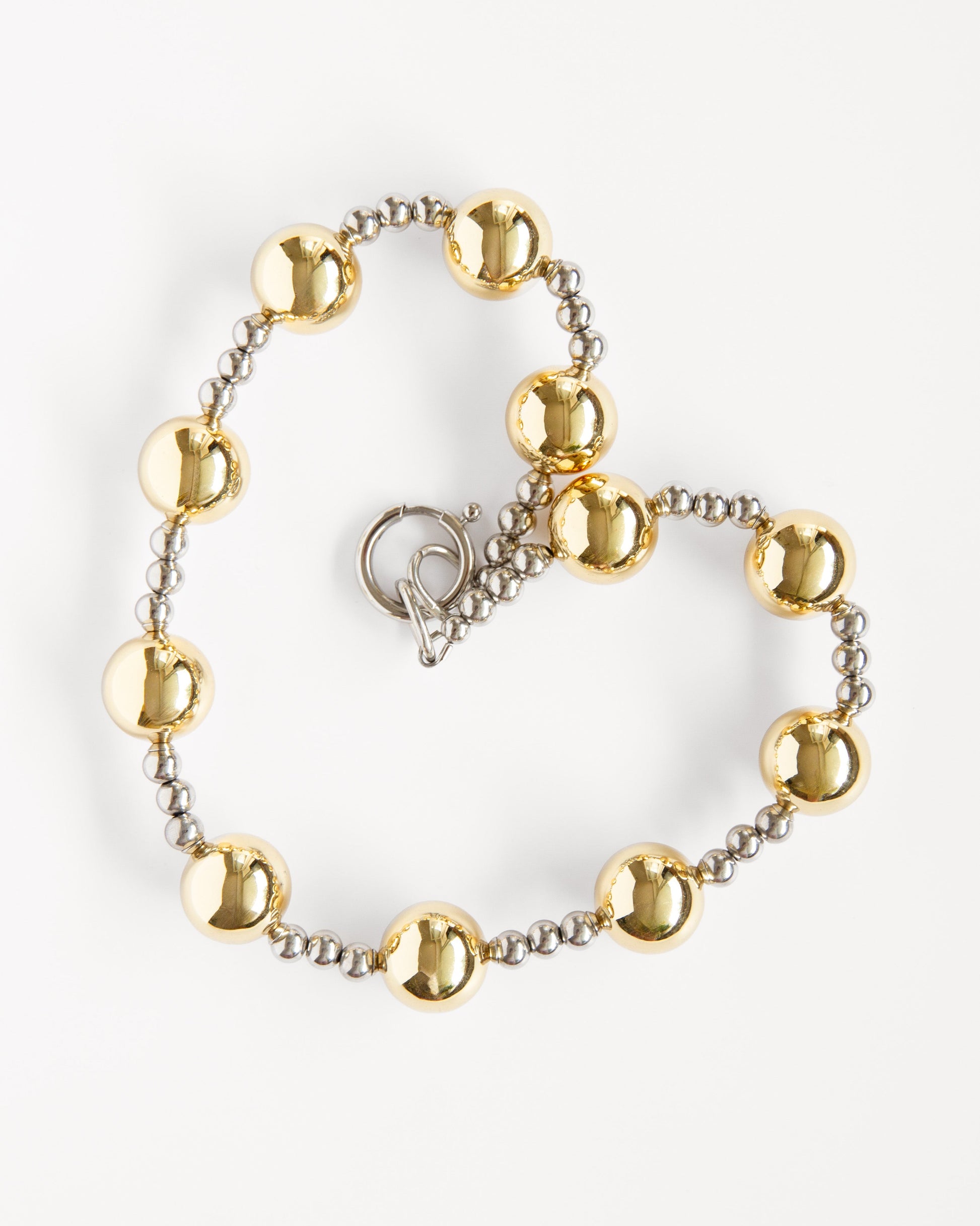mixed metal beaded necklace with gold and silver beads, close-up of clasp and chain detail on white background