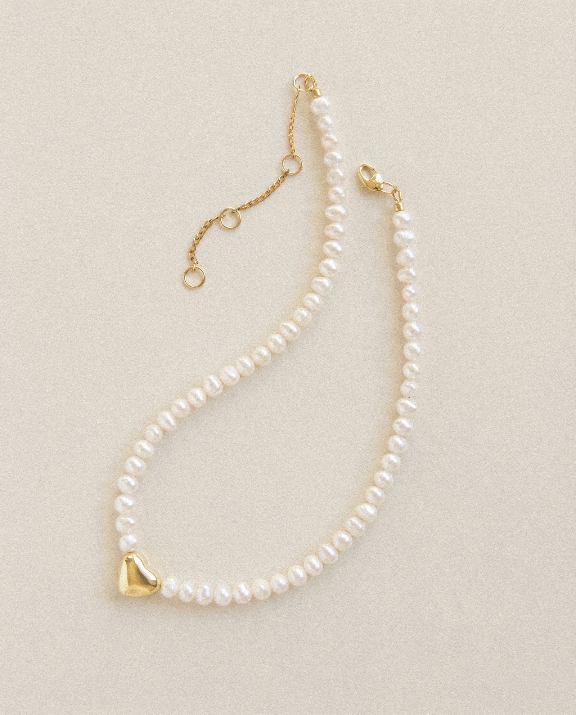 Freshwater pearl choker necklace with 18k gold plated heart charm, minimalist pearl necklace with extender chain on neutral background