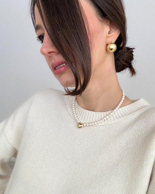 Model wearing the Heart of Gold pearl choker with an 18K gold-plated heart pendant — a refined, modern necklace that adds subtle glow to any look.
