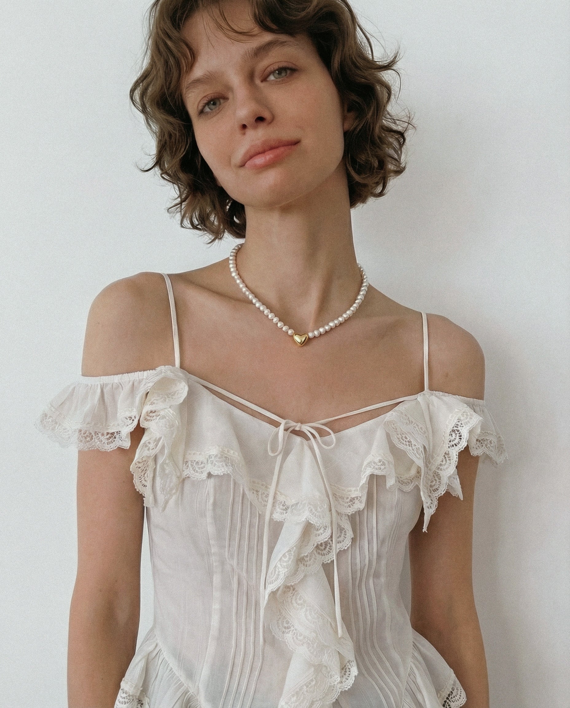 Freshwater pearl necklace with gold heart charm styled with romantic lace top, minimalist pearl choker for soft everyday look