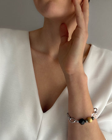 Minimalist Jazz Bracelet with stainless steel chain, clear quartz, black agate, and 18K gold-plated bead styled on model’s wrist