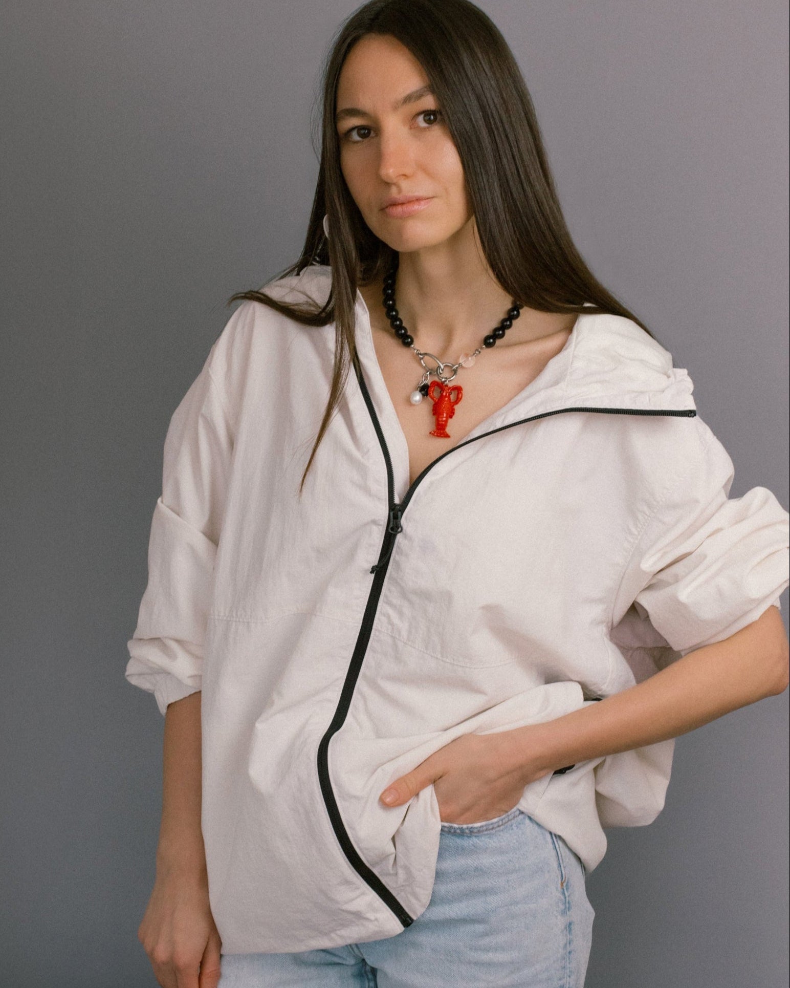 Jewell Reef Lobster Noir Necklace on model — bold black agate bead necklace with stainless steel clasp and detachable pendants. Styled with the red lobster charm, faceted black agate, and freshwater pearl, this statement jewelry piece brings a playful ocean-inspired accent to casual wear. A versatile necklace designed to balance elegance and fun, perfect for modern minimalist outfits with a twist.