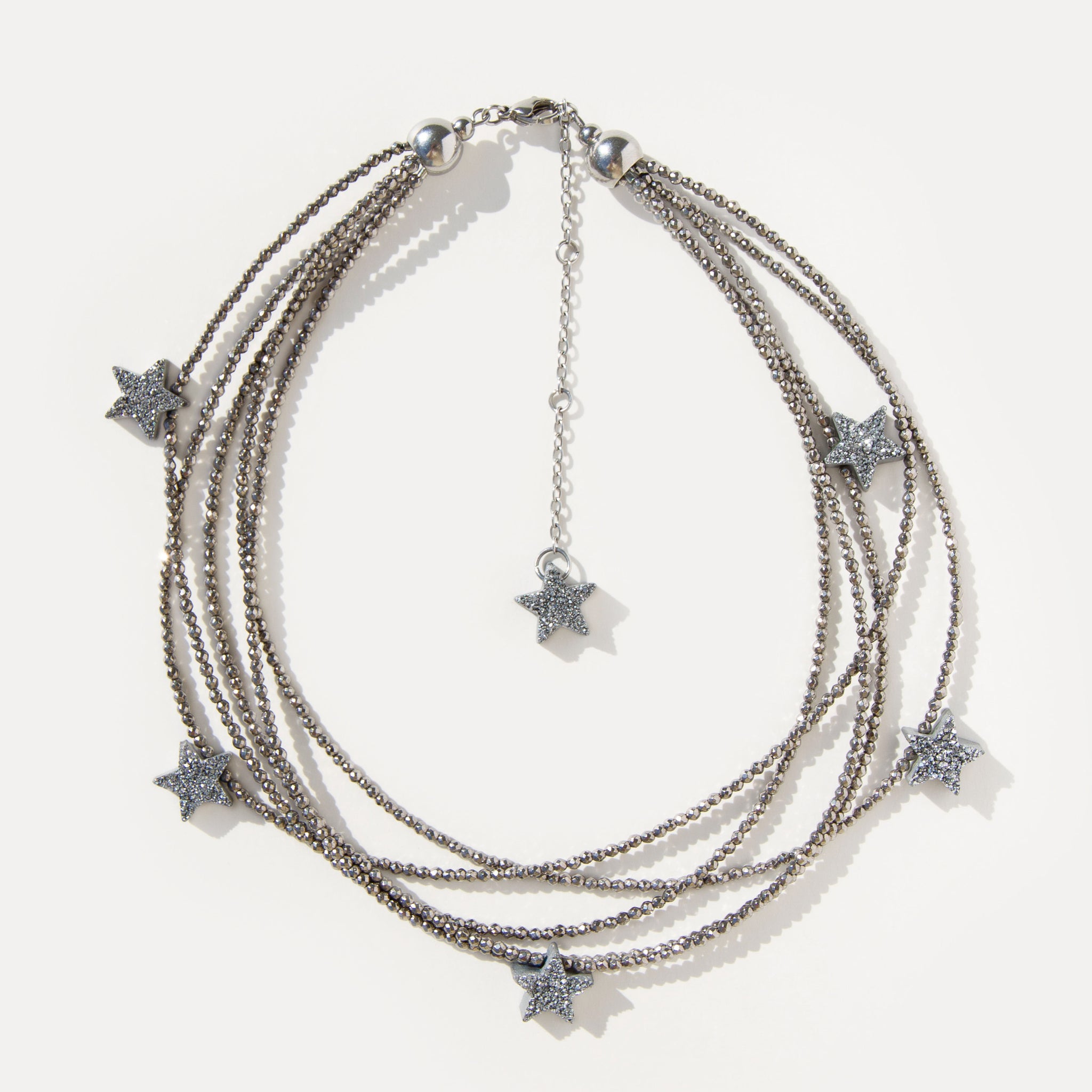 Make a Wish Necklace with five strands of shimmering hematite beads and druzy agate star charms. A layered statement necklace for modern styling.