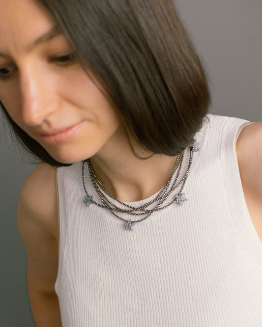 Make a Wish Necklace styled on model — five strands of hematite with druzy agate star charms. A layered statement necklace for day or evening wear.
