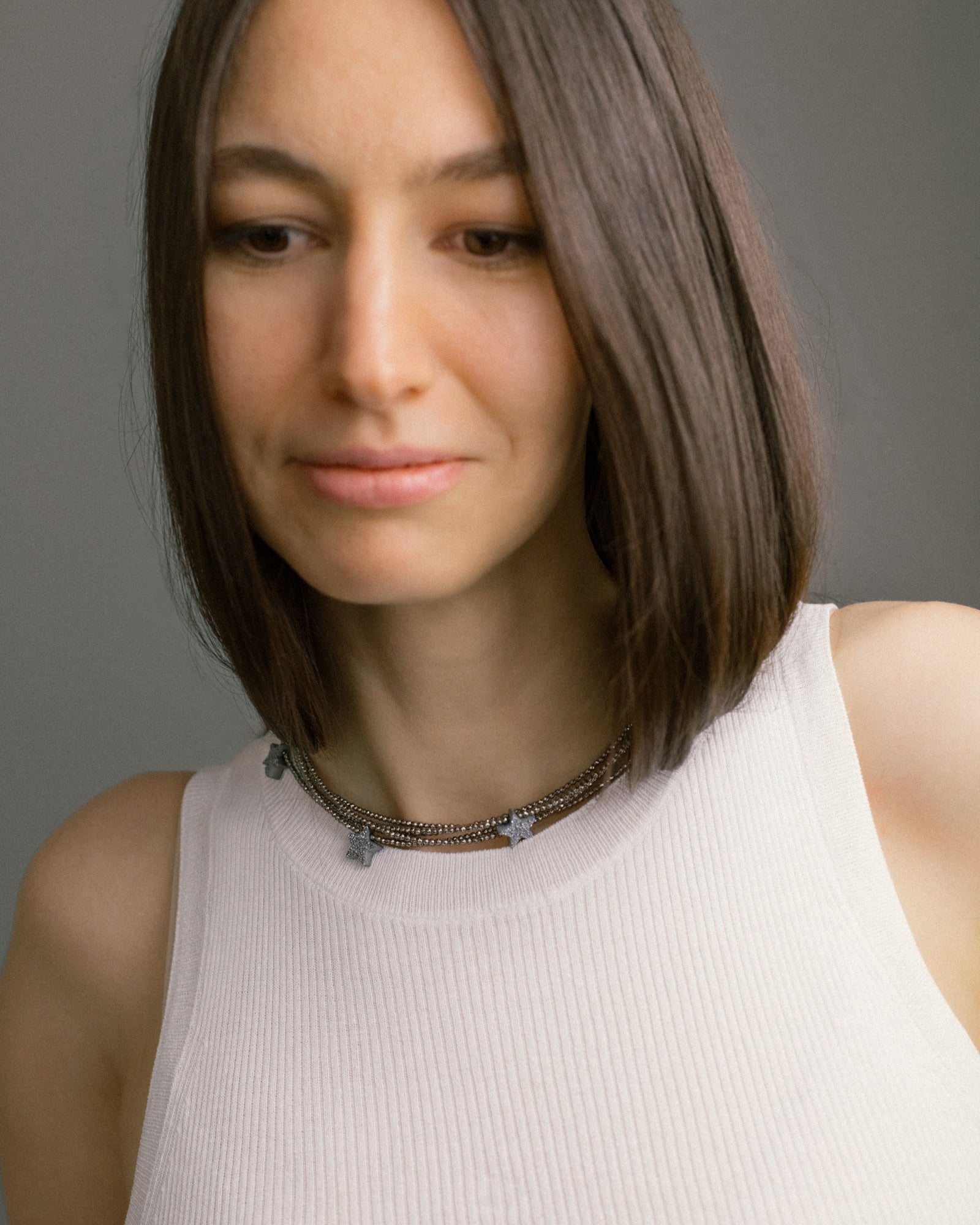 Make a Wish Necklace worn as a choker — layered hematite strands with druzy agate star charms. A bold multi-strand necklace for modern styling.