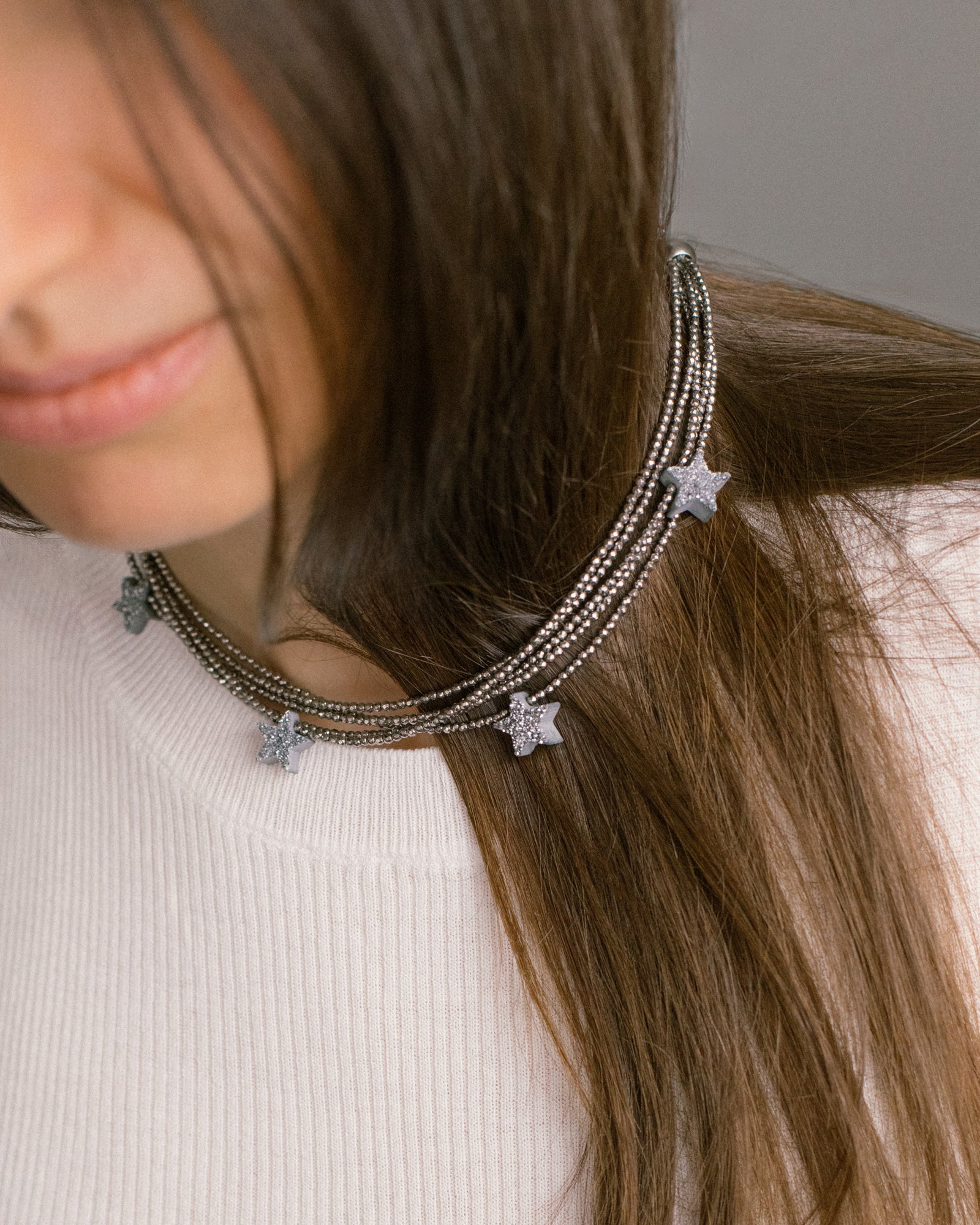 Make a Wish Necklace styled as a layered choker on model — hematite strands with sparkling druzy agate stars. A modern multi-strand statement necklace.