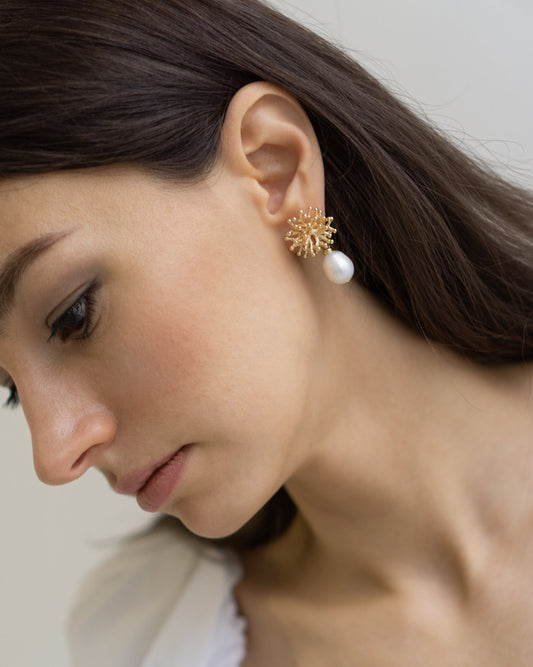 Mermaid’s Secret gold pearl earrings styled on model — coral-inspired studs with baroque pearls, reflecting soft light and quiet seaside elegance.