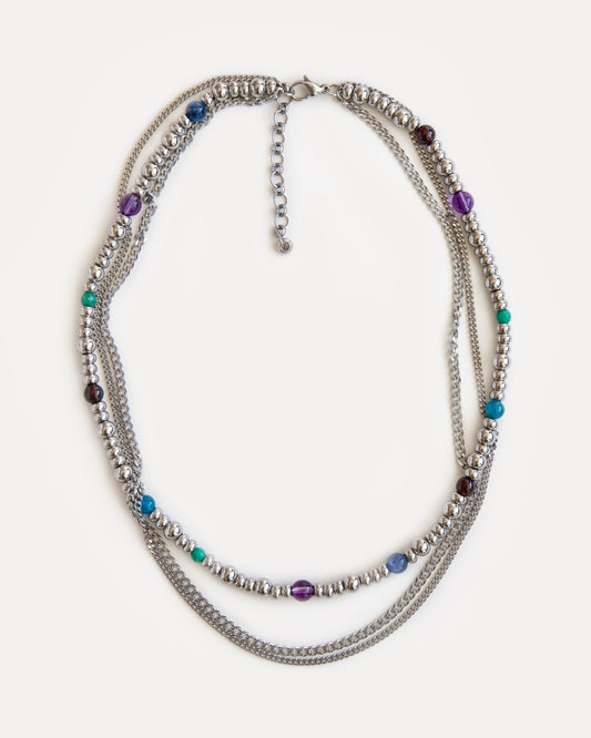 Full view of the GEMS necklace, a sophisticated three-layer design of durable jewelry steel chains and vibrant natural gemstones: garnet, amethyst, kyanite, amazonite, and apatite. Laid flat, the necklace displays its elegant symmetry and playful color combination, making it a versatile statement piece for any wardrobe. Explore Jewell Reef's unique, handcrafted fashion jewelry, perfect for layering or as a standalone gift.