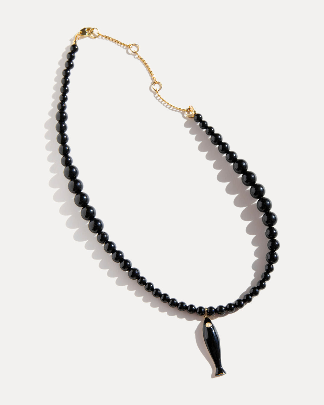 Black agate necklace with ceramic fish pendant and gold details, asymmetrical adjustable choker inspired by evening swims and coastal style