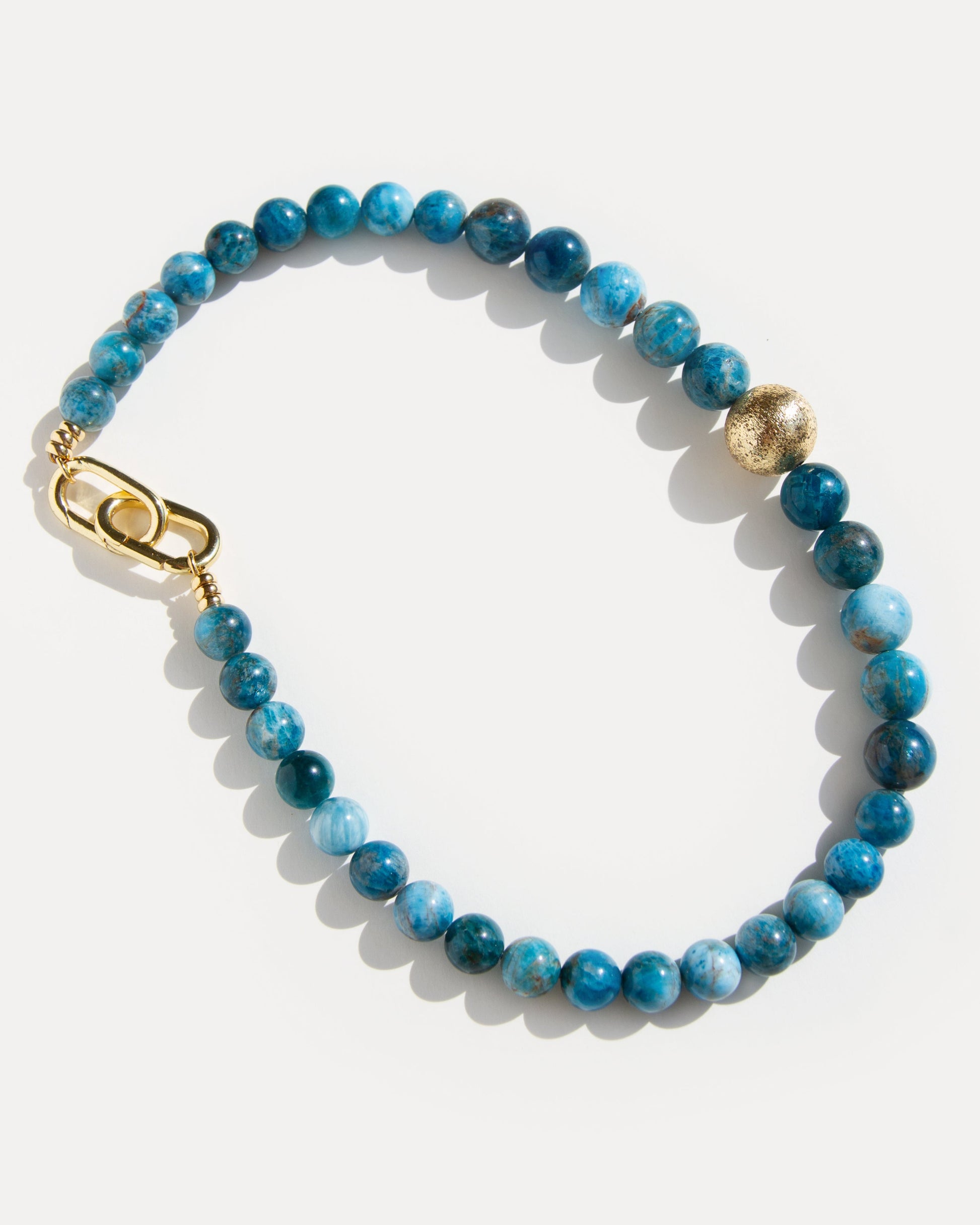 Blue apatite statement necklace with 18K gold-plated clasp and accent bead, inspired by ocean hues and modern minimalist jewelry design