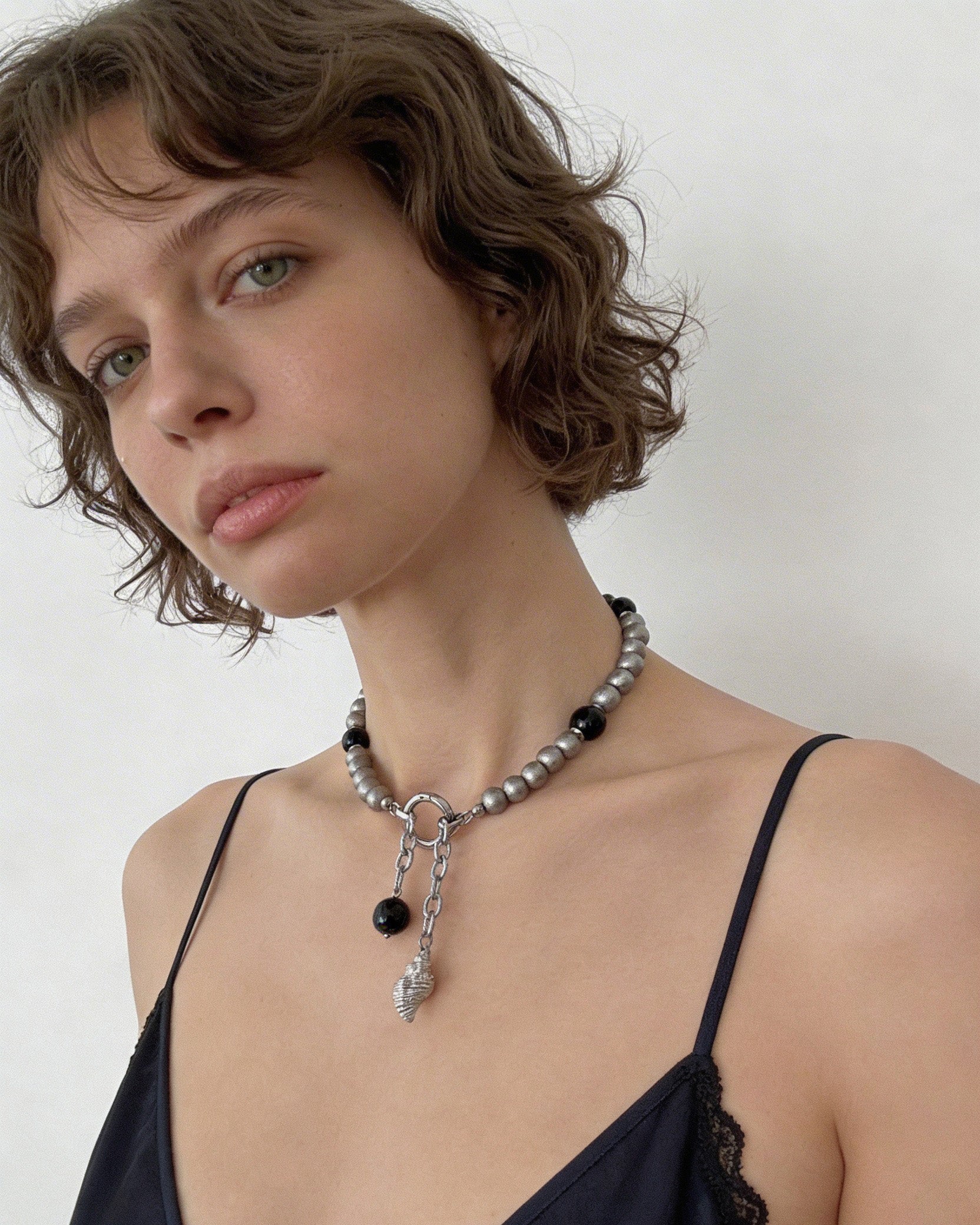 Black agate beaded choker necklace with stainless steel beads and shell pendant styled on model, modern minimalist natural stone jewelry