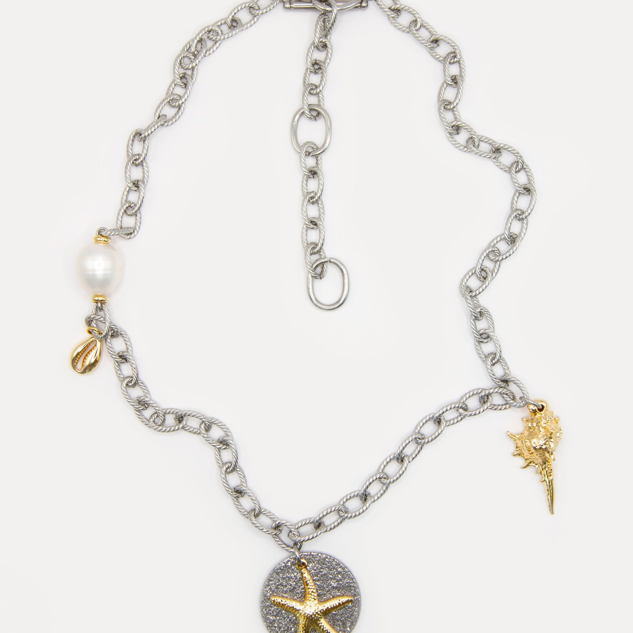 Sea Gifts Necklace with bold silver chain, freshwater pearl, golden shell, starfish and snail charms - a playful mixed metal jewelry piece with coastal charm.
