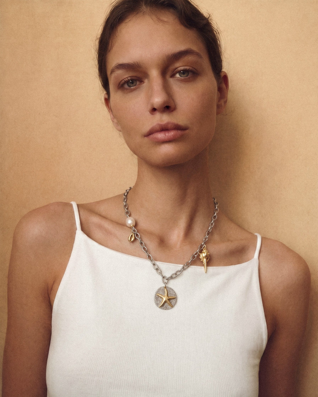 Sea Gifts Necklace with bold silver chain, freshwater pearl, golden shell, starfish and snail charms - a playful mixed metal jewelry piece with coastal charm.
