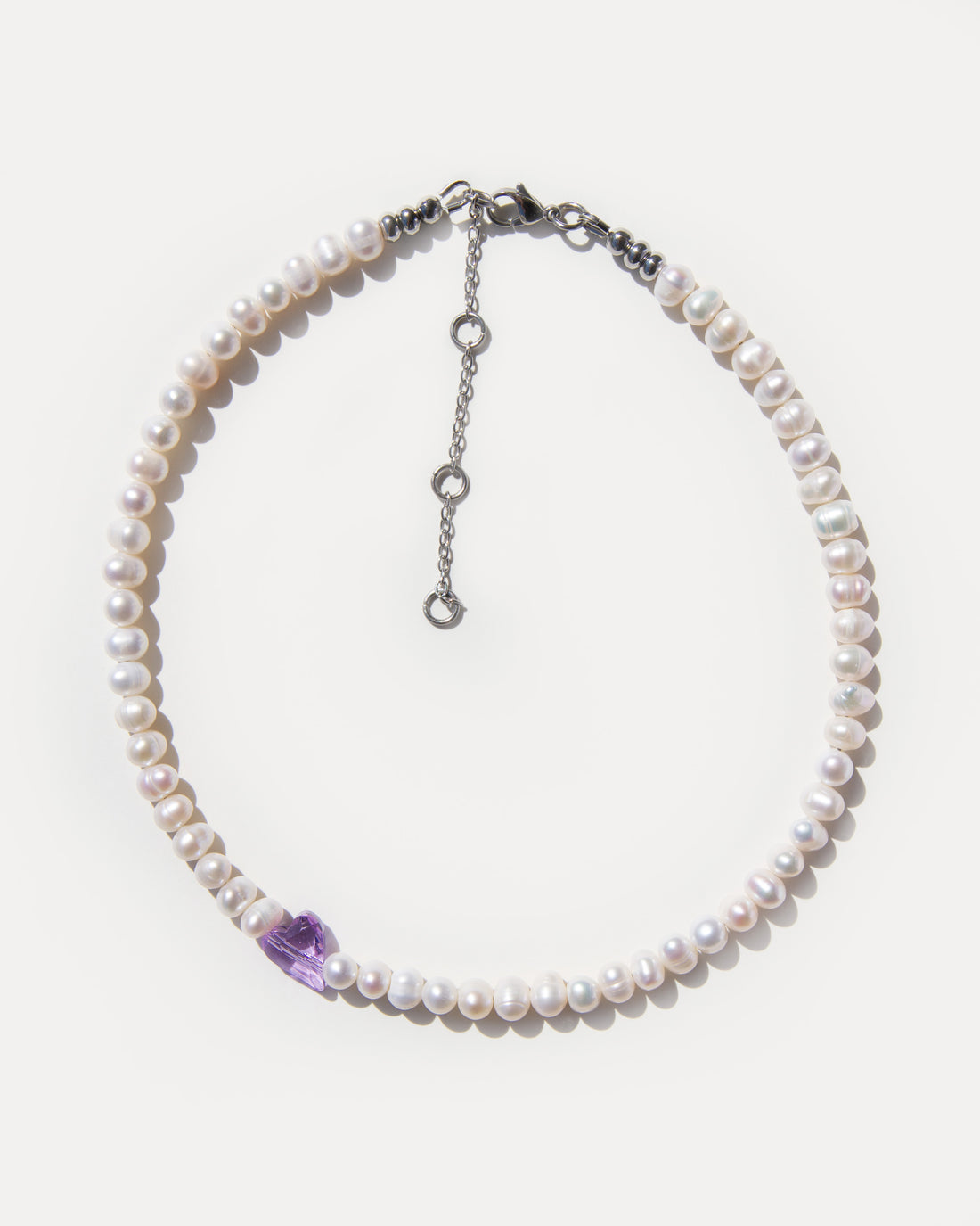 Sweetheart pearl choker necklace with natural freshwater pearls and a purple crystal heart accent, feminine and modern jewelry piece.