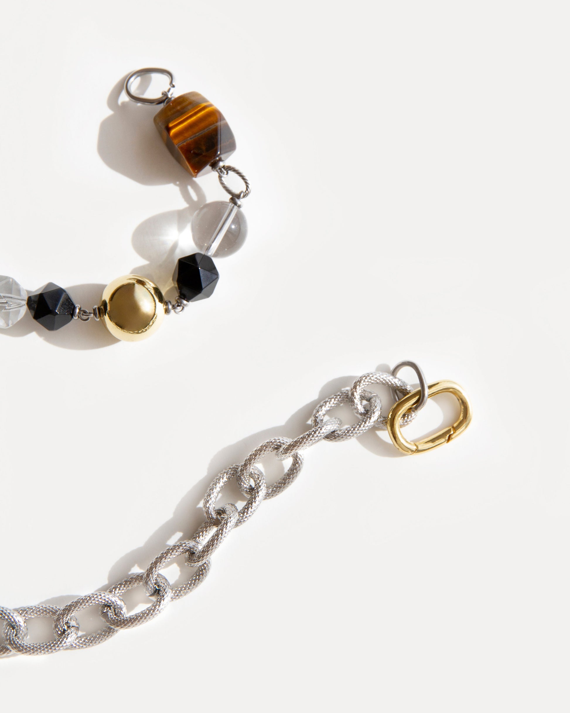 Close-up of Tiger Eye Necklace with polished tiger eye, agate, clear quartz and mixed metal chain, highlighting textures and gold-silver contrast.
