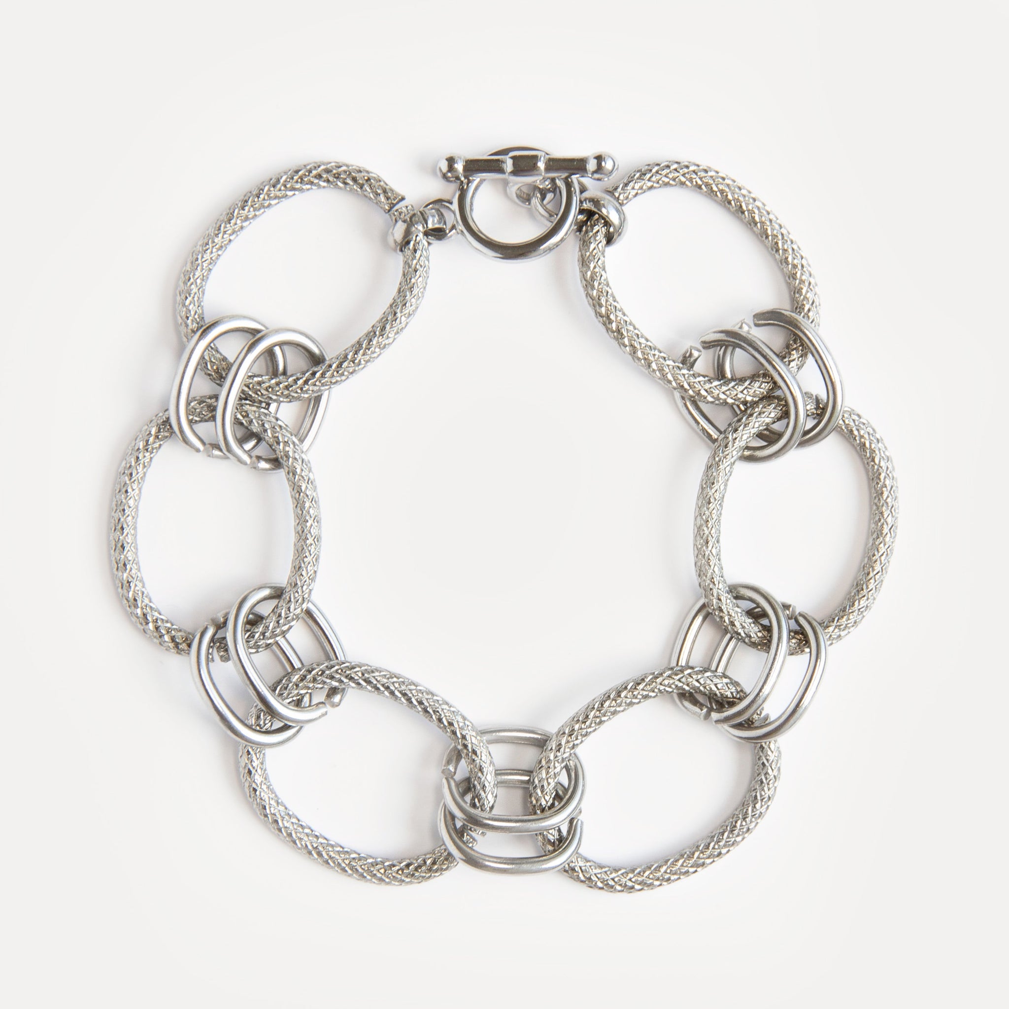 Bold stainless steel bracelet with textured woven links and modern clasp. A sculptural, timeless piece for everyday or statement styling.