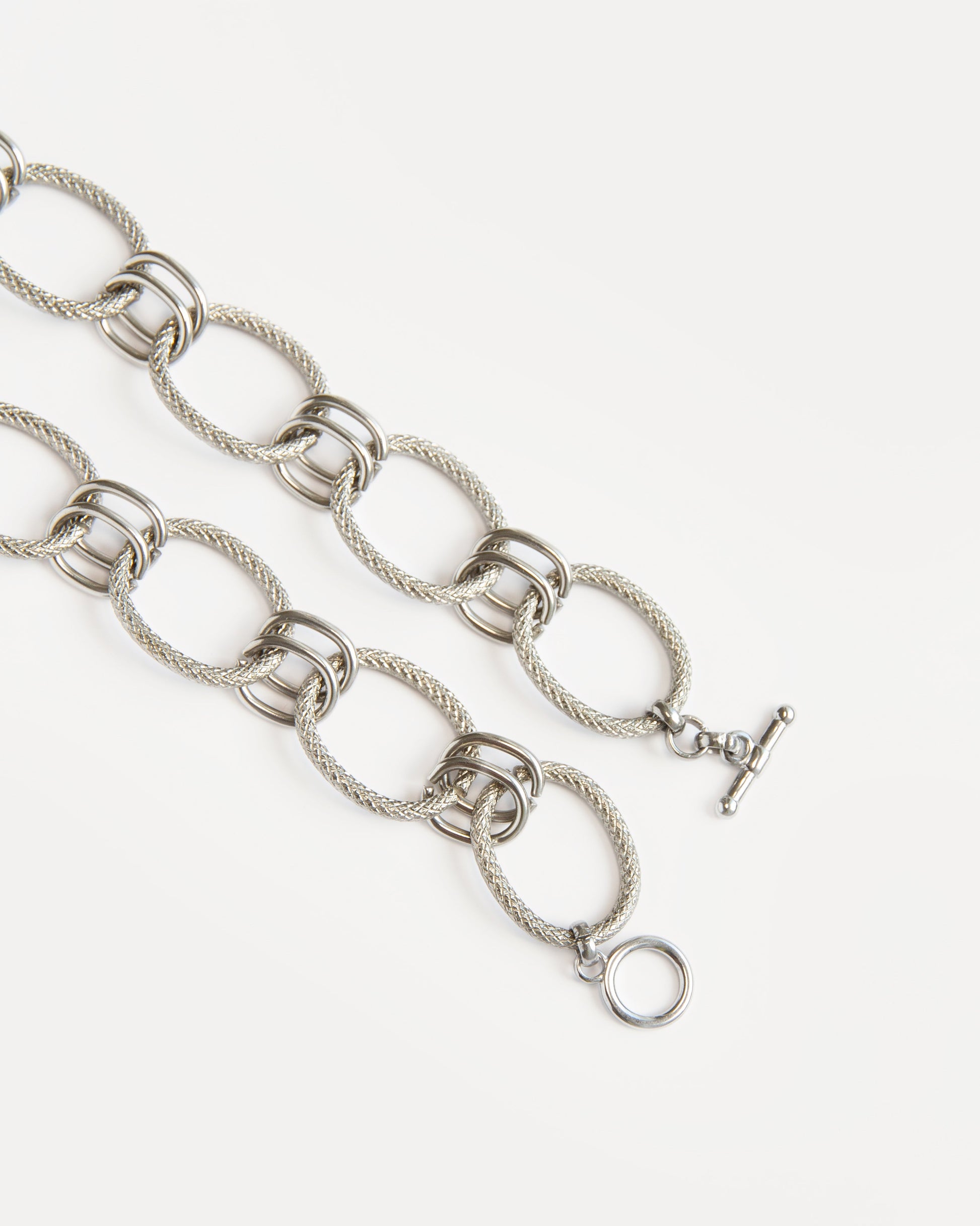 Close-up of the Venus Necklace showing textured oval links in polished stainless steel — a refined modern chain with sculptural, timeless design.