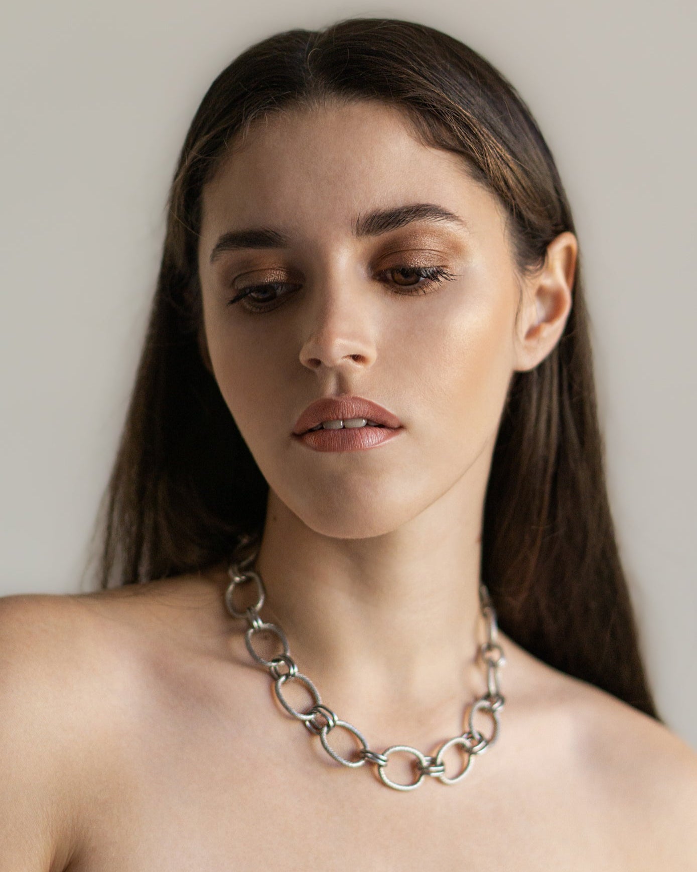 Close-up of the Venus Necklace on model — a bold stainless steel chain with sculptural links, adding a refined modern touch to any look.